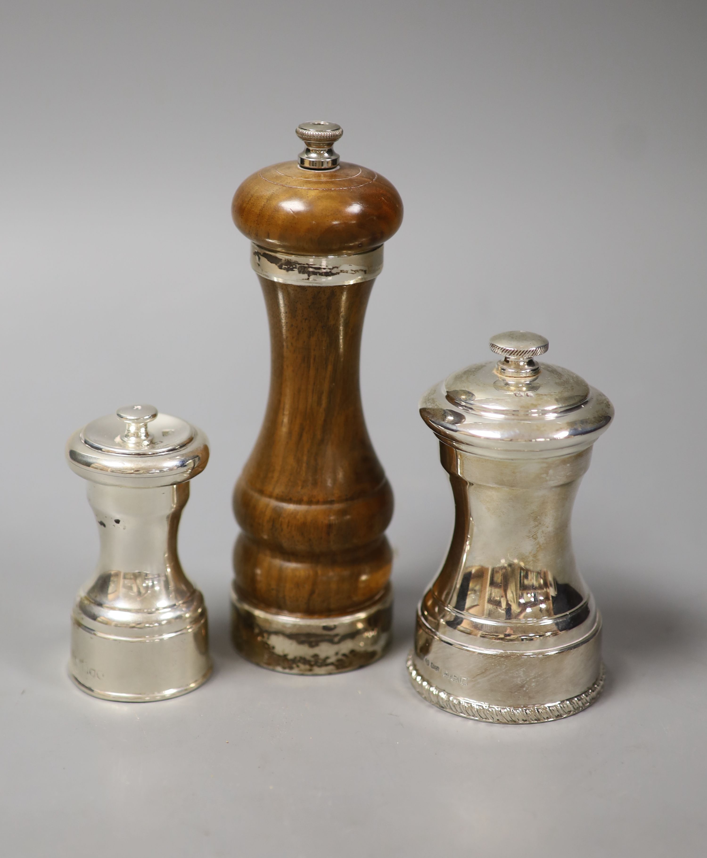 Two silver pepper mills and a silver-mounted wooden pepper mill (3)